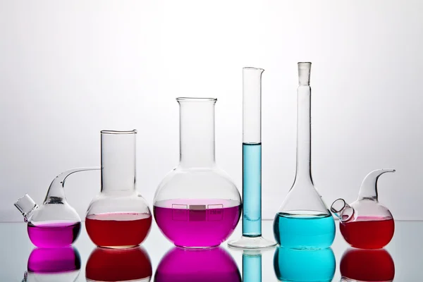 Laboratorieartiklar av glas med färgglada kemikalier — Stockfoto