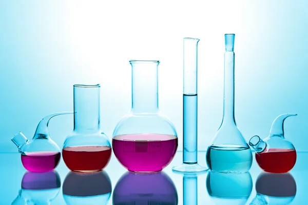 Vetreria da laboratorio con sostanze chimiche colorate — Foto Stock