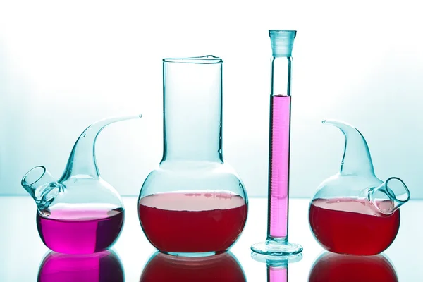 Artículos de vidrio de laboratorio con productos químicos de colores —  Fotos de Stock
