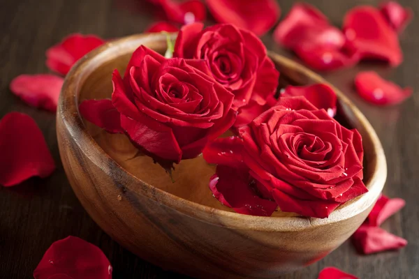 Rode rozen in houten kom — Stockfoto