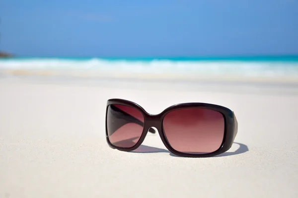 Γυαλιά ηλίου στην άμμο στην παραλία — Φωτογραφία Αρχείου