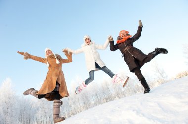 Happy girls jumping in the snow clipart