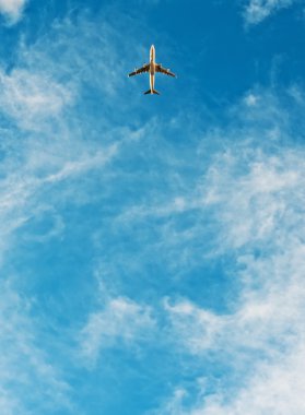 Airplane flying in blue sky clipart