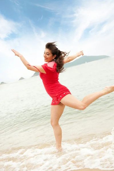 Beautiful young woman jumping in the sea — Stock Photo, Image
