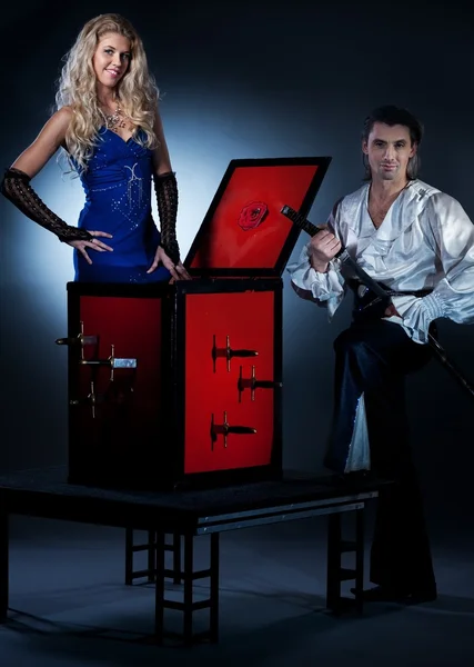 Attractive couple performing sword box illusion — Stock Photo, Image
