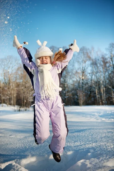 Счастливая девочка прыгает в снег — стоковое фото
