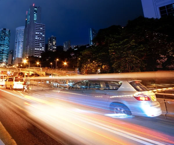 Carros em movimento rápido à noite — Fotografia de Stock