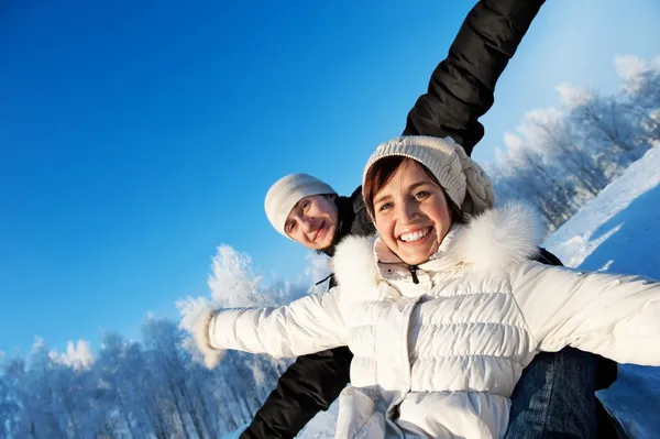 Счастливая улыбающаяся пара на зимнем фоне — стоковое фото