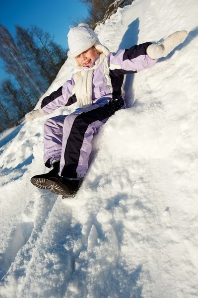 Menina deslizando na neve — Fotografia de Stock