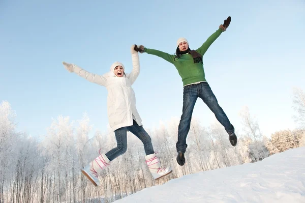 Couple drôle sautant sur un fond neigeux — Photo