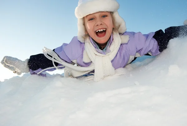 Kleines Mädchen rutscht im Schnee — Stockfoto