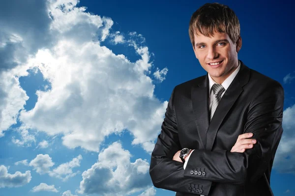 Молодой счастливый бизнесмен над облачным небом — стоковое фото