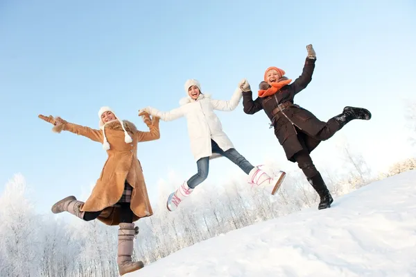Meninas felizes pulando na neve — Fotografia de Stock