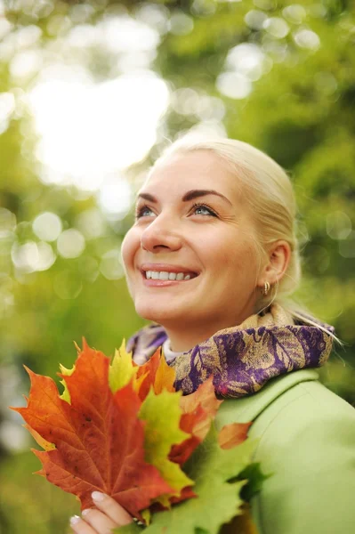 Женщина с золотыми осенними листьями — стоковое фото