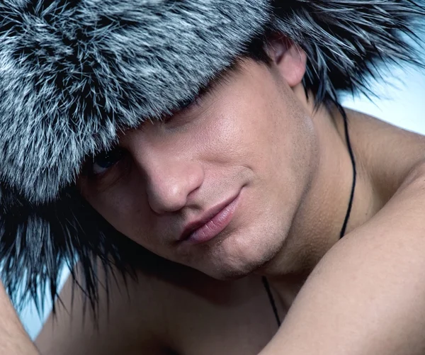 Портрет красивого молодого человека в пушистой шляпе — стоковое фото