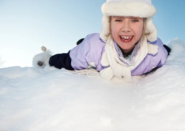 Kleines Mädchen rutscht im Schnee — Stockfoto