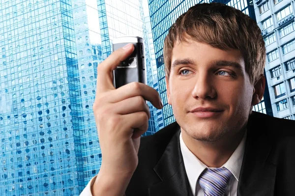 Молодой бизнесмен с мобильным телефоном напротив своего офисного здания — стоковое фото