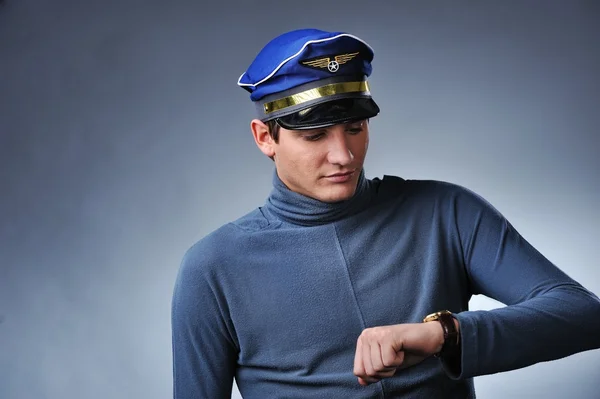 Przystojny pilot patrząc na zegarek — Zdjęcie stockowe