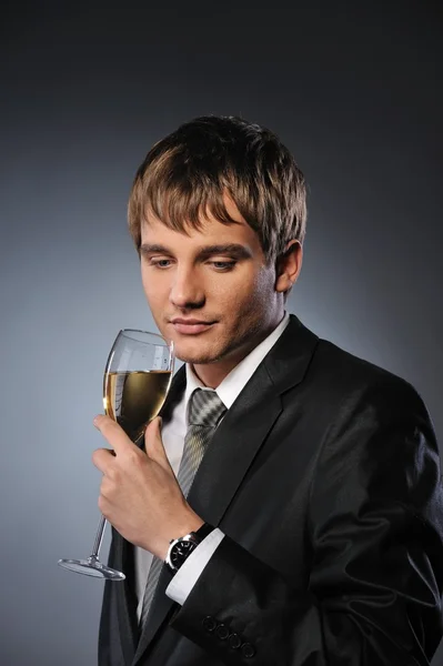 Jovem empresário bonito com uma taça de champanhe — Fotografia de Stock