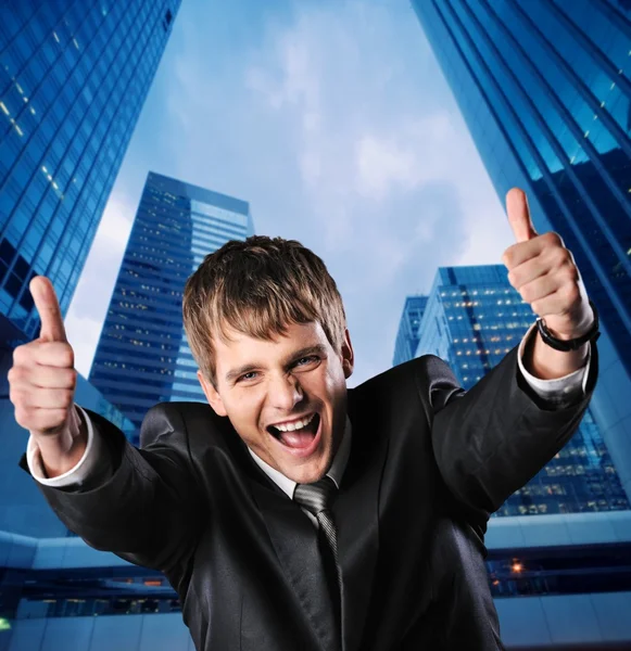Счастливый бизнесмен против своего офисного здания — стоковое фото