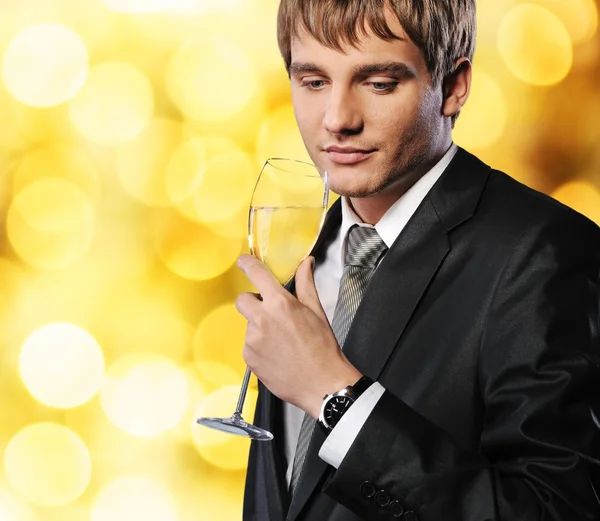 Бизнесмен с бокалом шампанского на абстрактном фоне — стоковое фото