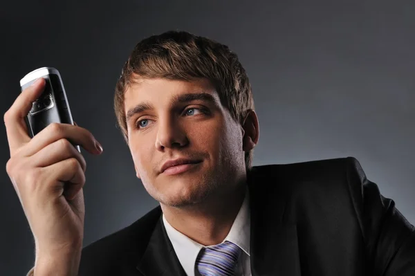 Jeune homme d'affaires tenant un téléphone portable — Photo