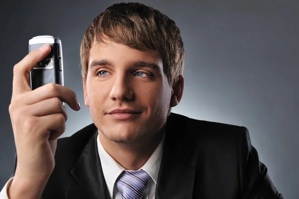 Young businessman holding mobile phone Stock Picture