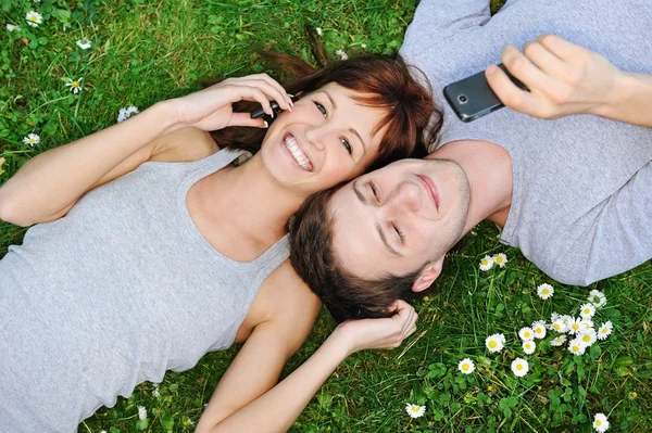 Junges Paar mit Mobiltelefonen im Freien lizenzfreie Stockfotos