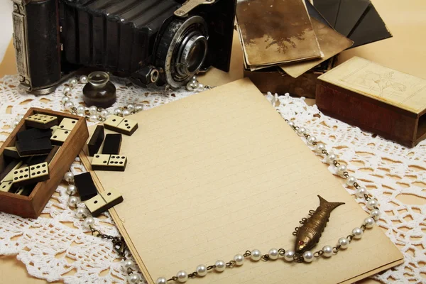 Prázdný list, retro fotoaparát, starožitný domino a šperky — Stock fotografie