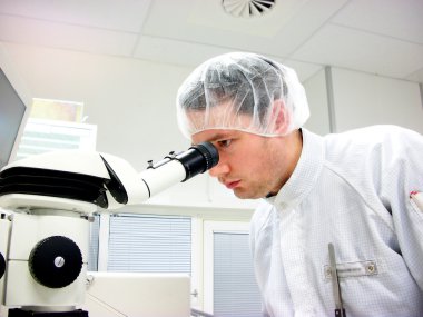 The men looks in stereomicroscope eyepieces clipart