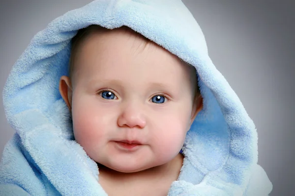 Close-up retrato de um bebê adorável em suave hod azul — Fotografia de Stock