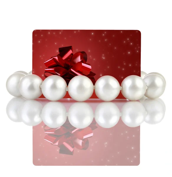 Perlas con tarjeta creativa de regalo roja con lazo —  Fotos de Stock