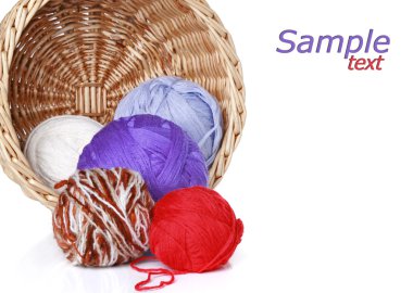 Multi-colored balls of yarn in wicker basket on a white background clipart