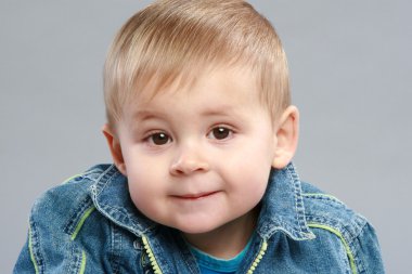 Adorable boy close-up portrait on grey background