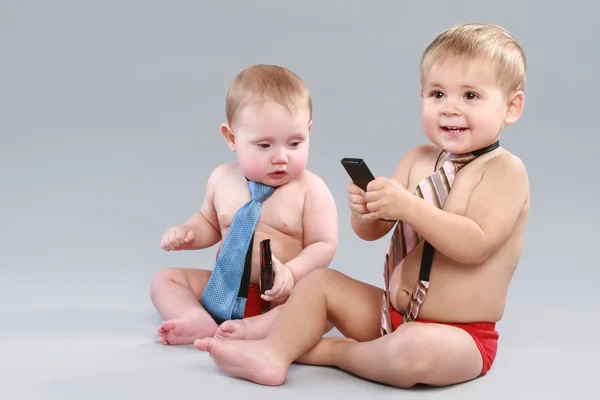 Dva Chlapce Kravatě Hrát Mobil Šedém Pozadí — Stock fotografie
