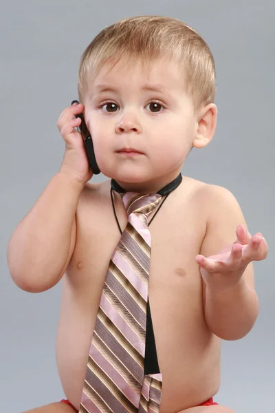 Little boy in tie speaks on a cell phone — Stock Photo, Image
