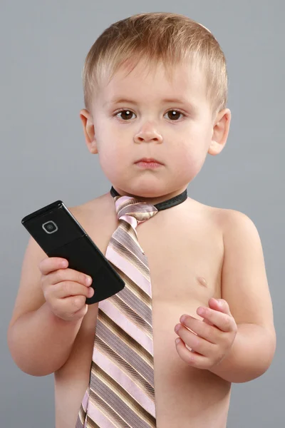 Visel egy döntetlen és egy cellphone kisfiú — Stock Fotó