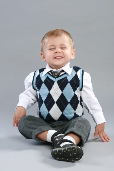 Little boy in a checkered sweater laughs — Stock Photo, Image