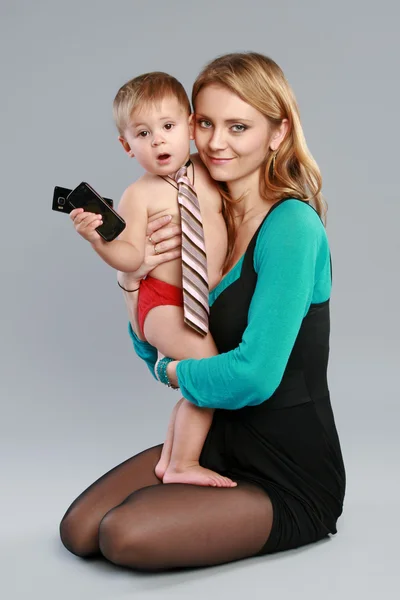 Jovem empresário com telefone celular sentado em suas mãos mãe — Fotografia de Stock