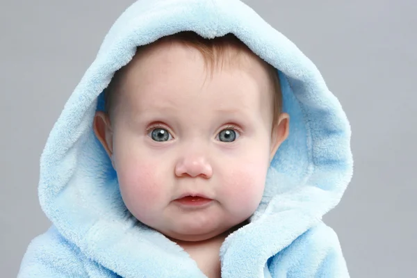 Schattige babyjongen in een blauwe badjas — Stockfoto