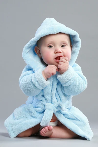 Adorável menino em um roupão de banho azul — Fotografia de Stock