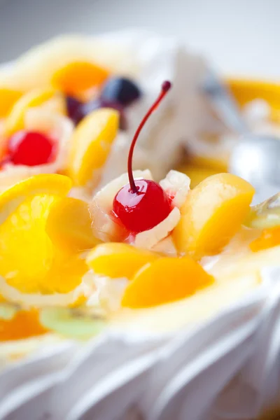 Torta decorada com frutas e uma cereja — Fotografia de Stock