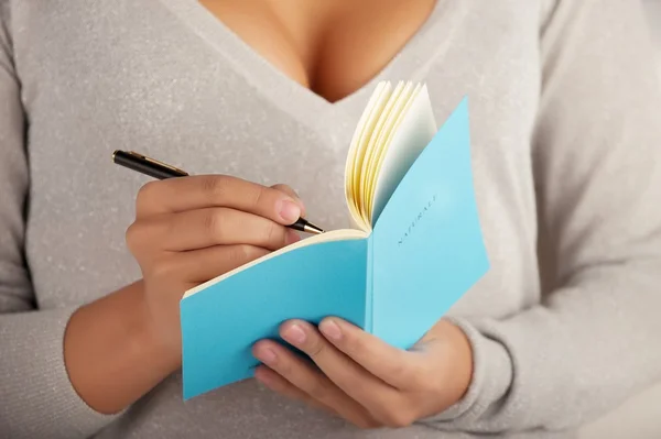 Young woman writes in the notebook — Stock Photo, Image