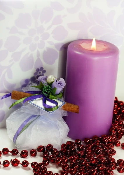 Свадебная коробка конфет, приглашение и зажженная свеча — стоковое фото
