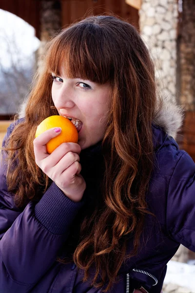 Meisje oranje eten — Stockfoto