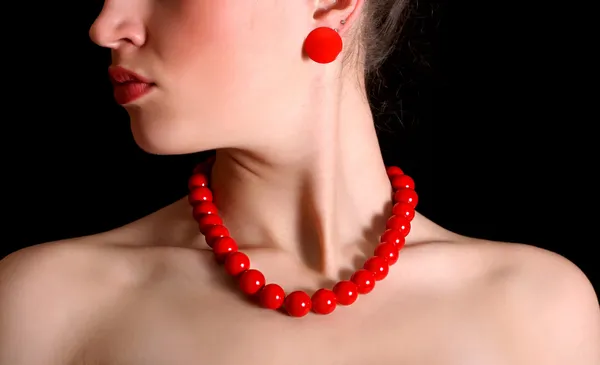 Red beads and a round shackle around neck of beautiful girl — Stock Photo, Image