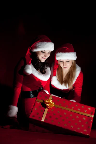 Dwie kobiety w kostium santa otwierając prezent na Boże Narodzenie. — Zdjęcie stockowe