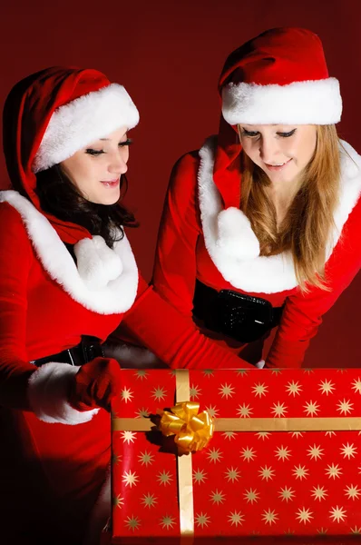 Två kvinna i santa dräkt öppna julklapp — Stockfoto