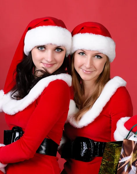 Dvě ženy v oblečený jako santa, s nákupní tašky . — Stock fotografie