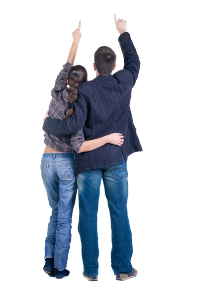 Young couple pointing at wall. Rear view — Stock Photo, Image